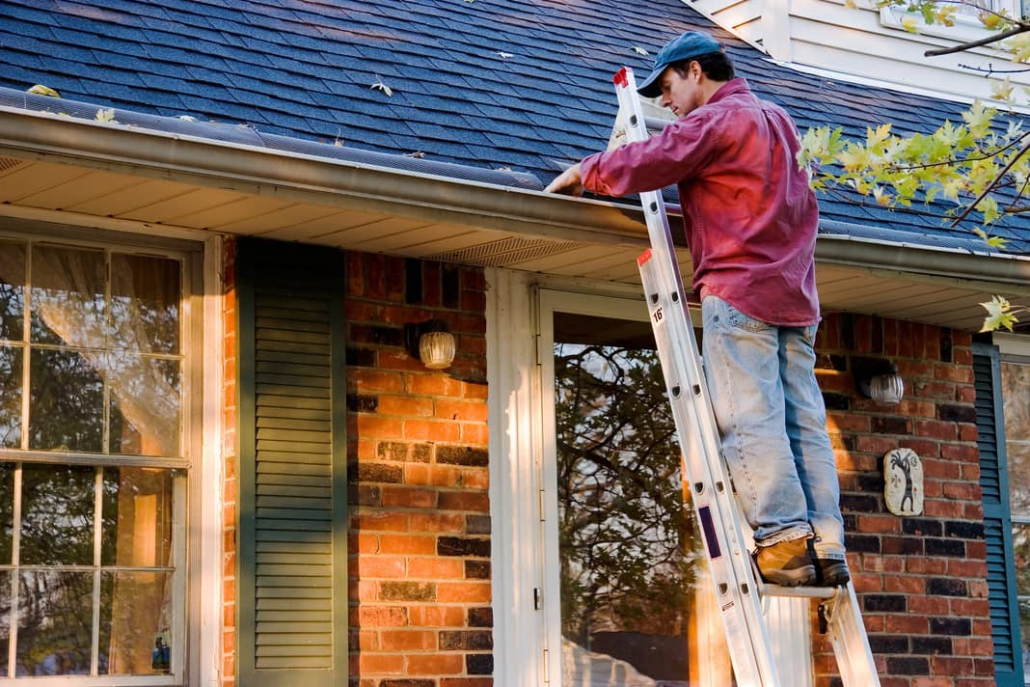 Cleaning gutters while on a ladder